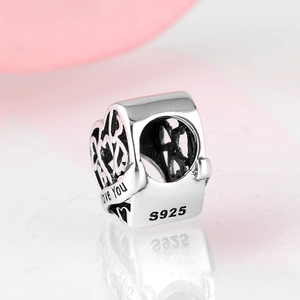 Macro detail of S925 sterling silver heart bead with Love You engraving and hollow design