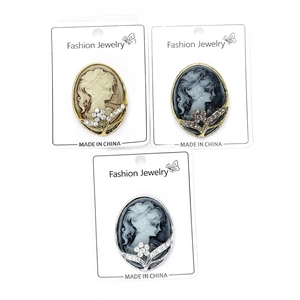 Close-up of vintage cameo brooches with floral rhinestone edges on display cards