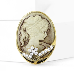 Macro detail of oval cameo brooch featuring a vintage female portrait and rhinestones