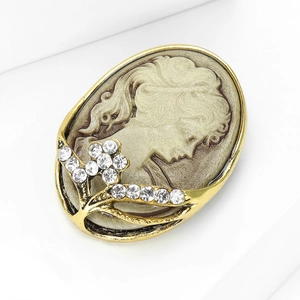 Macro detail of vintage relief lady portrait brooch with shimmering crystal floral inlay