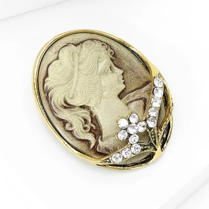 Detail of vintage cameo brooch featuring relief portrait with crystals and floral accents