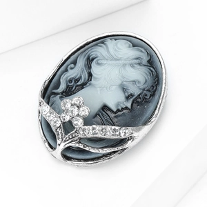 Macro detail of vintage relief cameo brooch with silver floral frame and crystals