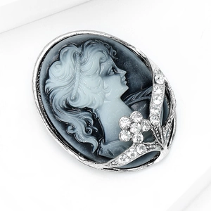 Macro shot of Victorian vintage cameo brooch with floral rhinestones and silver frame