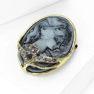 Detailed macro view of vintage relief brooch with grey crystals and golden frame