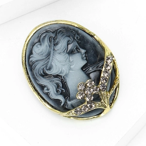 Macro detail of vintage cameo brooch with embossed female portrait and sparkling rhinestones