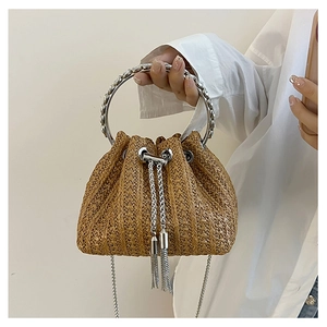 Detail of straw bucket bag with metal round handle and sparkling tassel drawstring
