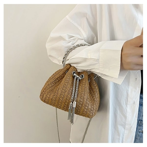 Detail of straw bucket bag with rhinestone drawstring tassel and silver metal ring handle