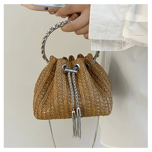 Detail of straw bucket bag with silver ring handle and metal fringe drawstring