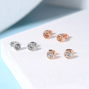 Three pairs of 4mm round cubic zirconia stud earrings in silver and rose gold finish
