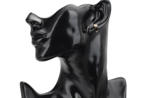 Detailed view of 4mm gold round textured stud earrings on a black mannequin model