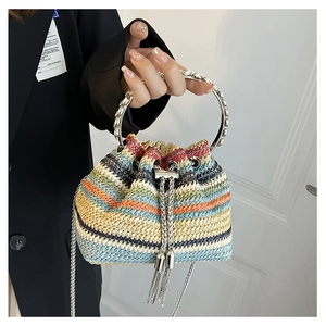 Detail of multi-color striped woven bucket bag with silver metal ring handle and tassels