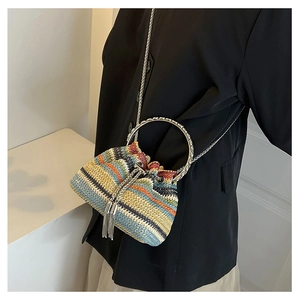 Detail of colorful woven straw bucket bag with silver metal ring handle and chain strap