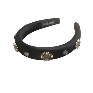 Padded black headband with grey oval gemstones and pearl beads on a white background