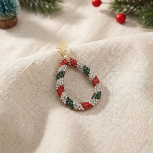 Christmas teardrop earrings with colorful rhinestones and gold star on linen background