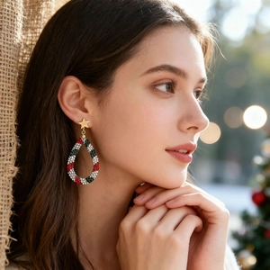 Macro shot of Christmas earrings featuring golden stars and colorful rhinestones