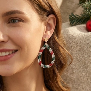 Close-up of star and teardrop earrings with red and green crystals for Christmas