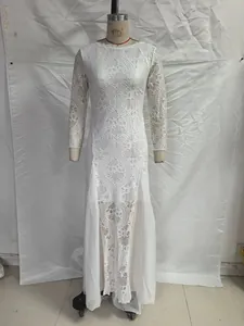 Macro detail of white lace wedding gown featuring intricate floral patterns and tulle paneling