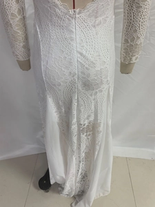 Close-up of intricate floral lace pattern and sheer texture on a white evening dress
