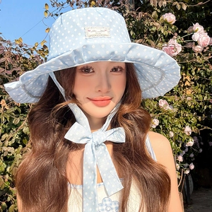 Detail of light blue polka dot sun hat with wide brim and matching chin strap for summer