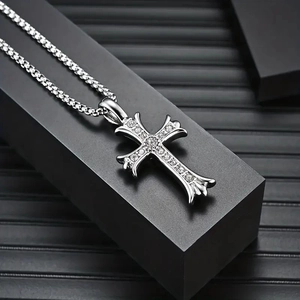 Gothic silver cross pendant with crystals on a square pearl chain over a black pedestal