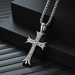 Close-up of hip-hop cross pendant set with sparkling stones on a black box chain
