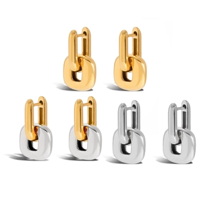 Three pairs of stylish bicolor and monochrome stainless steel U-shaped earrings on white