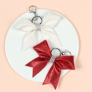 Detail of glitter bow keychains with sparkling rhinestones in red and iridescent white