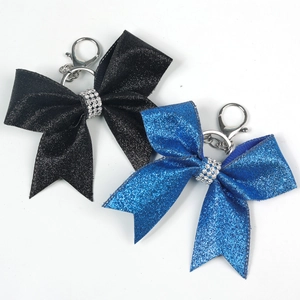 Close-up of glitter bow keychain in black and royal blue with rhinestone centerpiece detail