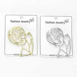 Close-up of gold and silver hollow portrait brooches with rhinestones on cards