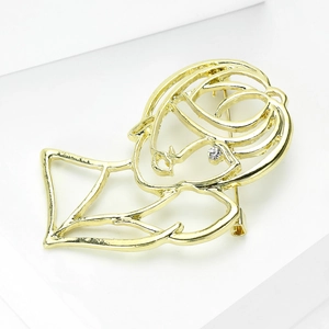 Detail of a hollow gold human face brooch with a sparkling rhinestone eye detail