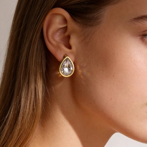 Elegante 18k vergulde roestvrijstalen druppelvormige oorsteker met zirkoon op een model