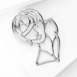 Detail of silver abstract female face brooch with crystal eye on polished alloy