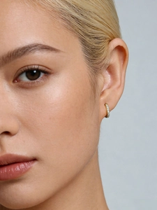 Close-up of a 7mm gold sterling silver hoop earring with paved cubic zirconia on ear