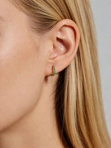 Close-up of 925 sterling silver gold hoop earring with pavé green zirconias on ear