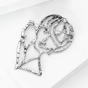 Detailed view of silver alloy abstract hollow portrait brooch with hammered texture