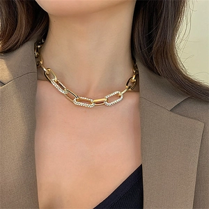 Detail of chunky gold chain necklace featuring sparkling rhinestone-encrusted link accents