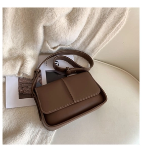 Detail of dark brown vintage square bag featuring contrast stitching and adjustable strap