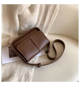 Detail of vintage chocolate brown crossbody bag with contrasting cream stitching and strap