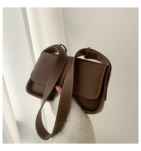 Detail of vintage brown shoulder bag with white contrast stitching and matte finish
