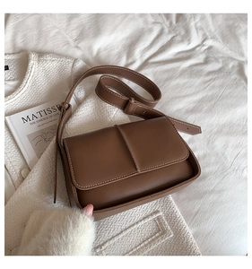 Brown leather crossbody bag detail showing contrast stitching and dual compartments