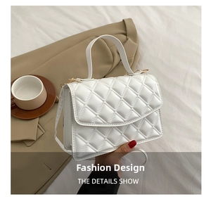 Detail of white quilted texture and gold hardware on minimalist commuter crossbody bag
