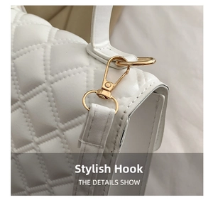 Detailed close-up of white quilted leather bag showing golden metal hook and hardware