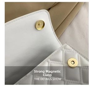 Detail shot of the gold magnetic closure on a white quilted crossbody handbag
