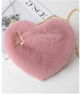 Detail view of pink heart-shaped faux fur bag with gold chain and teardrop zipper