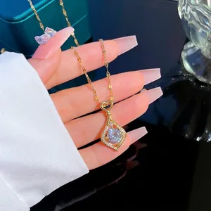 Gold plated water drop necklace with sparkling zircon pendant held by a hand