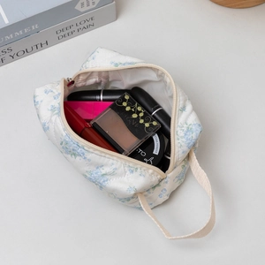 Interior detail of quilted floral makeup bag showing lipstick and cosmetic storage space