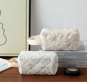 Detailed macro view of quilted floral and cat pattern makeup bags with cotton fabric texture