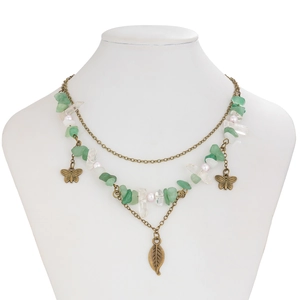 Detail of bohemian layered necklace with green stones, pearls and butterfly charms