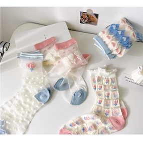Detail of sheer mesh crew socks featuring tulip embroidery and ruffled edges in pastel tones