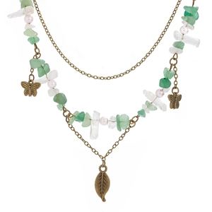 Detail view of retro double-layer necklace with green stones, crystal and leaf charms